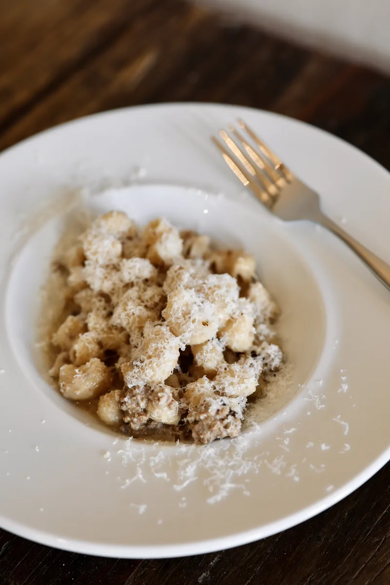 Frisk pasta med ragù og revet parmesan i en dyb tallerken